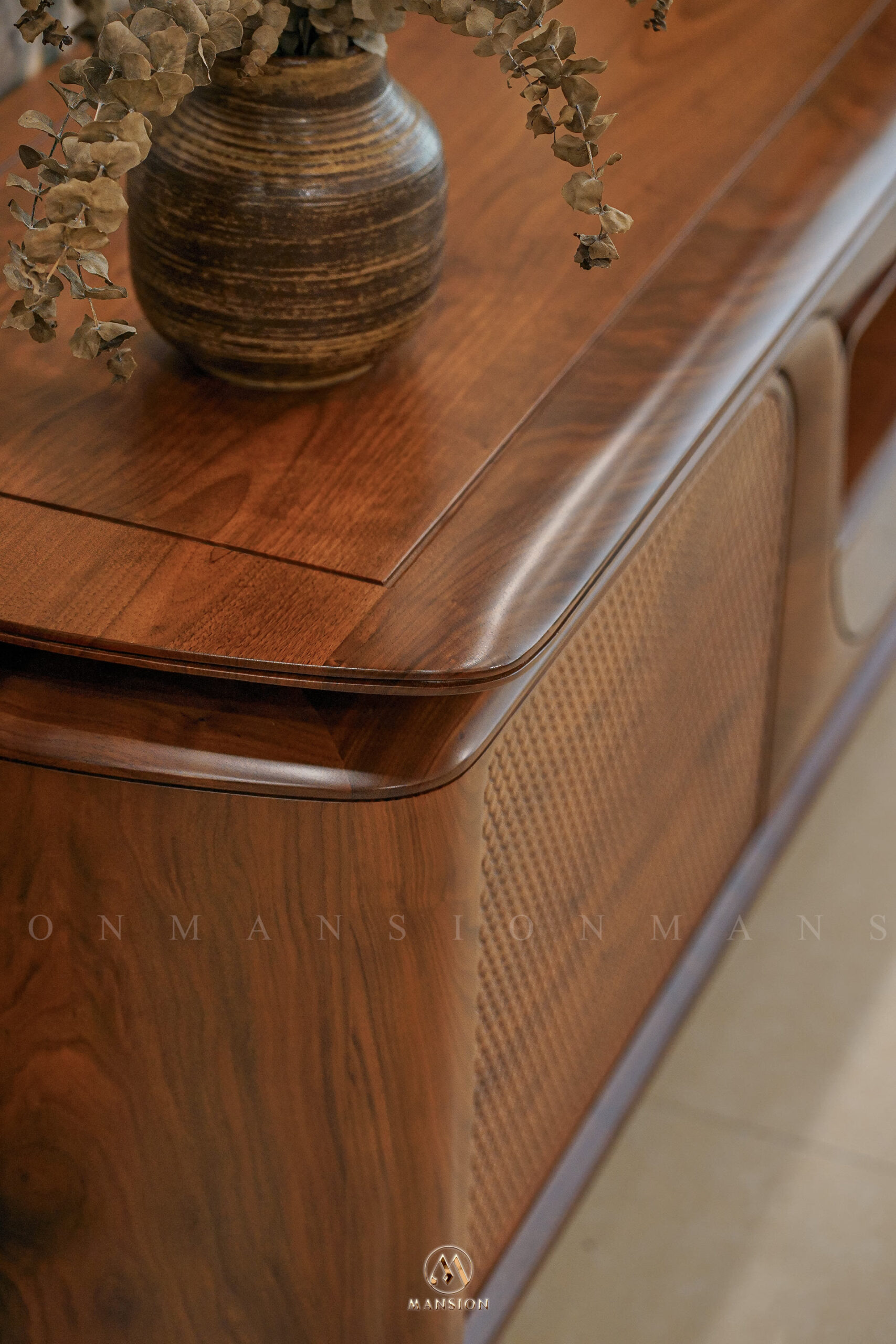 Cận cảnh vân gỗ óc chó và cánh mây đan trên tủ trưng bày tại showroom Mansion